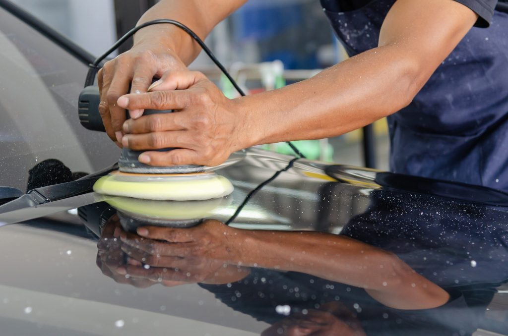Photo of man polishing car to remove scratches
